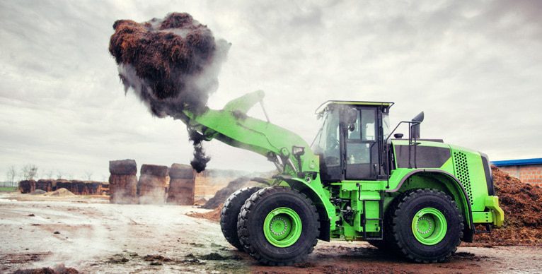 Front end loader lifting organic waste