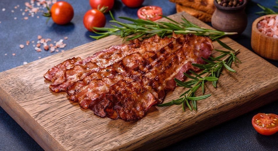 cooked bacon arranged on a board