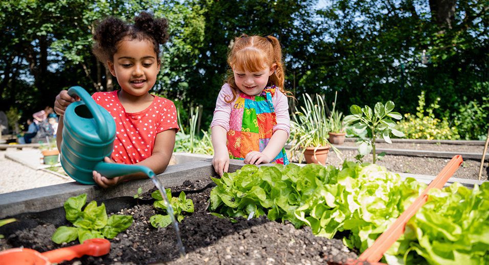 two little girls gardening in the backyard