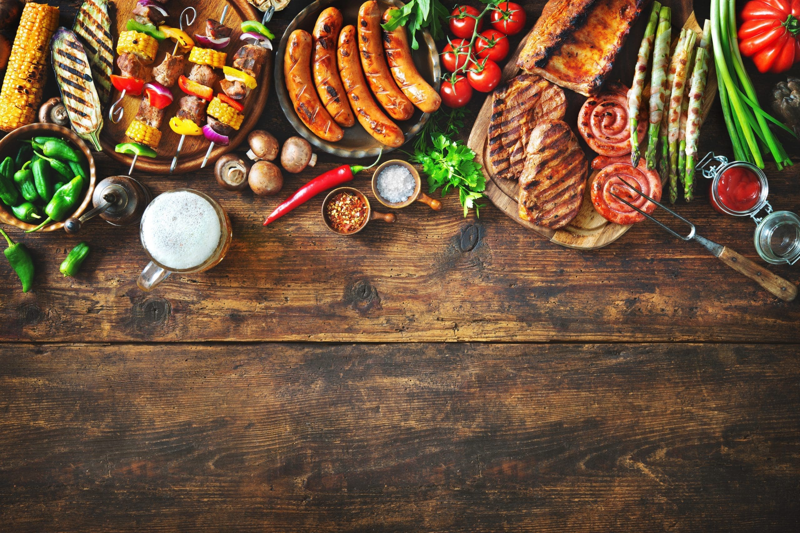 BBQ spread, including sausages and skewers with vegetables