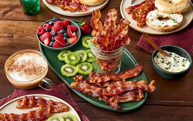 breakfast foods with bacon and fruit on the sides