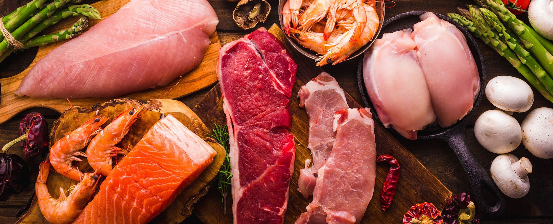 table full of raw meats and vegetables
