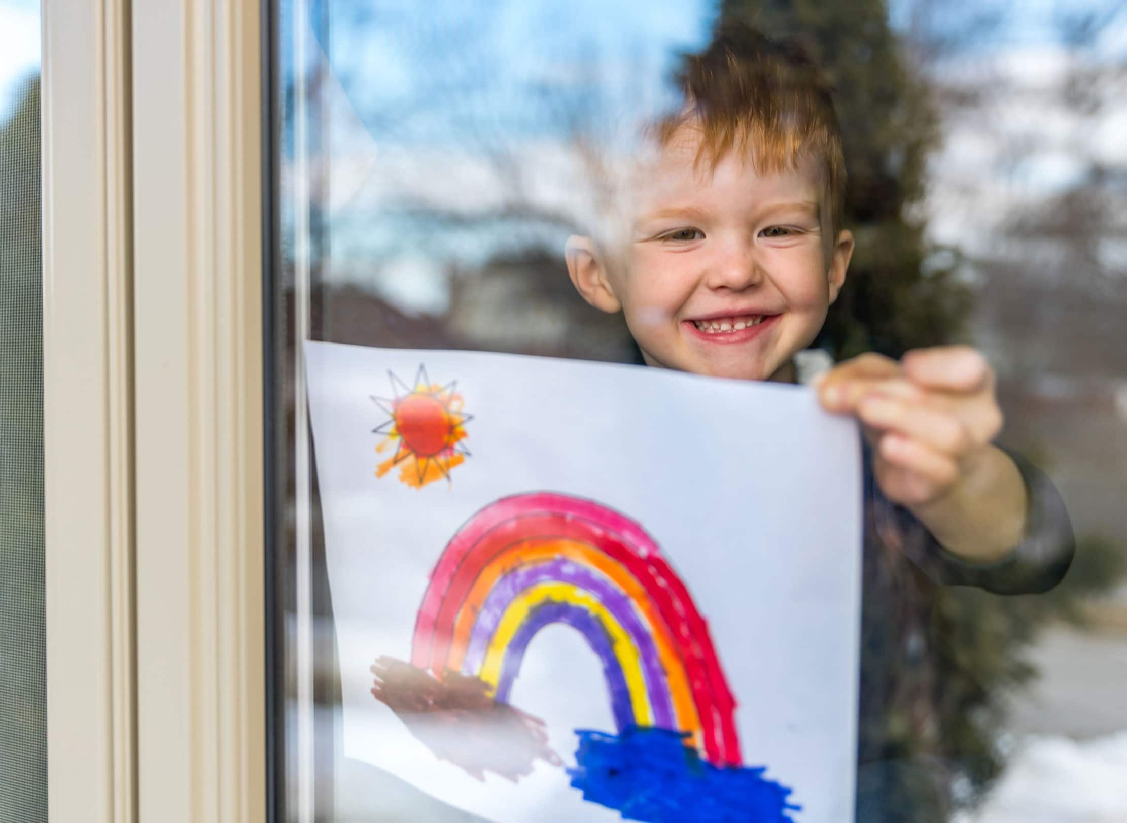 enfant souriant tenant un dessin