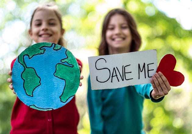 Deux filles brandissant des panneaux de sauvegarde de la terre