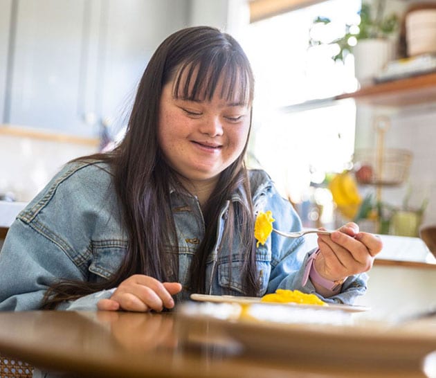 Fille mangeant à la table de la cuisine